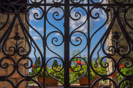 Wrought iron gate with sea and flowers in the backgroundの写真素材