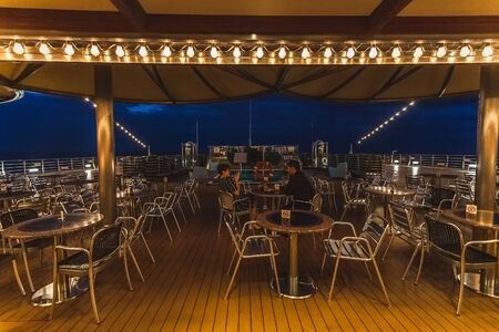 Passengers relaxing in the evening, in the open bar of ship