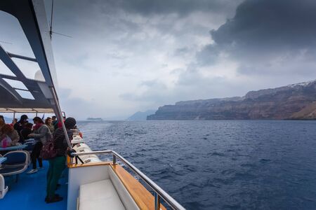 Cruise passengers on a boat waiting to get off the island on a rainy dayのeditorial素材