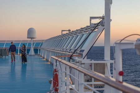 Passengers on the upper deck of a cruise ship at sunsetのeditorial素材