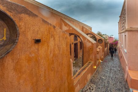 Tourists walking along Oia street near a restaurant, Santoriniのeditorial素材