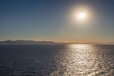 Reflections of the setting sun over the sea with Salamis island backgroundの写真素材