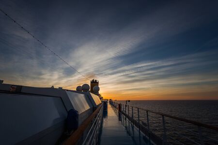 Spectacular sunset over the sea seen from the upper deck of a cruise shipの写真素材