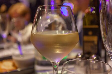 Glass of white wine with bokeh effect backgroundの写真素材