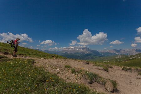 Woman observing her phone in a beautiful dolomitic pathのeditorial素材