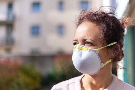 Woman with tousled hair and mask for coronavirus quarantineの写真素材