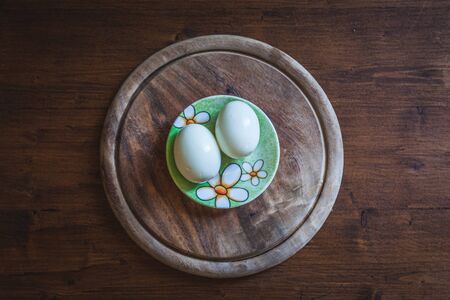 Top view of pair of eggs on rustic wooden plateの写真素材