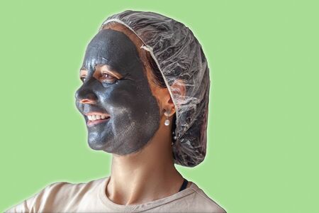 Smiling woman with gray clay maskの写真素材