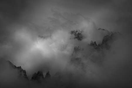 Sunrise over the Dolomite peaks half hidden by clouds and fog, Atmosphere of tranquility, relaxation...