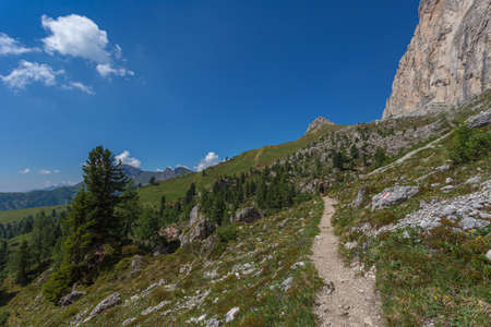 Unrecognizable woman walking on a hiking trail in a wonderful dolomite scenery, Settsass, Dolomites, Italyの写真素材