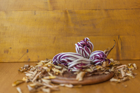 Red radicchio on wooden table with a base of dry yellow leavesの写真素材
