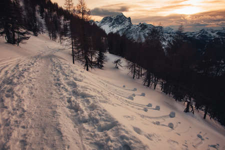 Dramatic colors effect of dolomite winter panorama at sunset with sunlit cloudsの写真素材