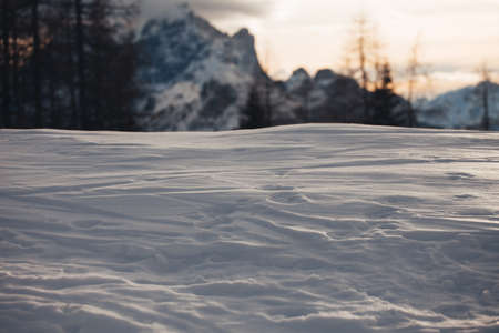Snow-covered surface illuminated by the setting sunの写真素材