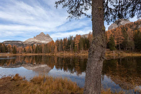 Reflection of autumn colored forest on dolomitic lakeの写真素材