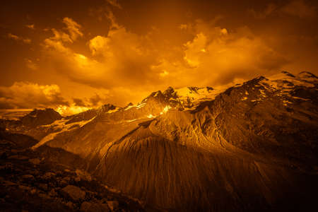 Golden color effect of the Palla Bianca peaks with clouds