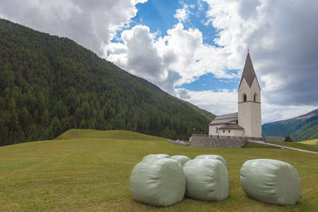 Isolated traditional church in the middle of meadows of South Tyrolean valleyの写真素材