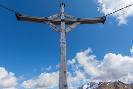 Cross on summit of alpine peak and Palla Bianca massif in the backgroundの写真素材