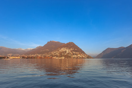 Sunset panorama of Lugano lake with Swiss mountains in the backgroundの写真素材
