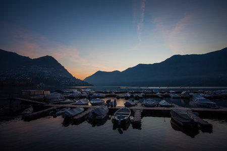 View of Lugano lake in November early morning with mooring for pleasure boatsの写真素材