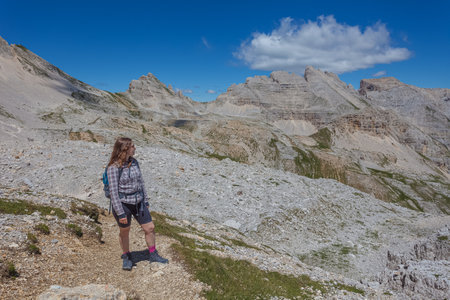 Young woman with long hair looking at the summer panorama in the Dolomitesの写真素材