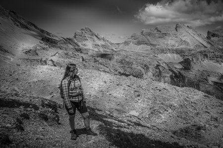 Young woman with long hair looking at the summer panorama in the Dolomitesの写真素材