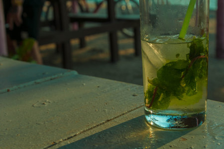 Refreshing mojito cocktail sitting on table in outdoor beach barの写真素材