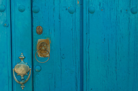 Old blue rustic wooden door with metal handle and knocker