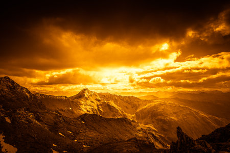 Fantasy effect color of alpine panorama with peaks under dramatic skyの写真素材