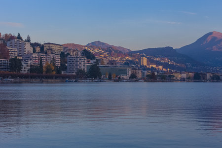 Sunrise autumnal panorama of Lugano city overlooking the homonyms lakeの写真素材