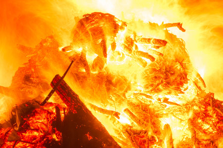 Large bonfire burning wood with bright orange flames