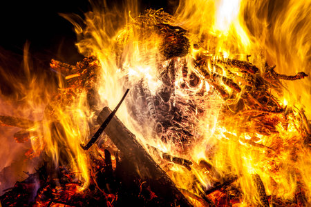 Large bonfire burning wood at night providing warmth