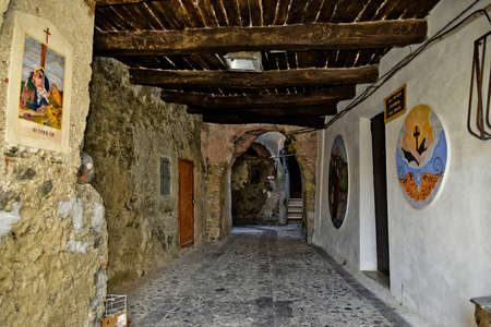 An alley with religious images painted on the walls in the old town of Grisolia, in the mountains of the Calabria region, Italy.のeditorial素材