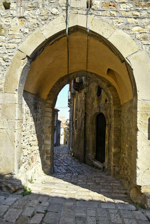 A narrow street among the old houses of Baselice, a medieval village in the Campania region, Italy.