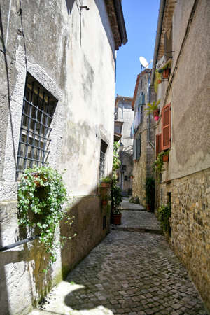 Bassiano, Italy, 05/10/2021. A narrow street between the stone buildings of a medieval town in the Lazio region.のeditorial素材