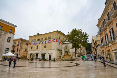 Matera, Italy, 12/03/2021. A square of an ancient city. Few people are seen in the winter rain.