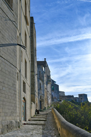 A narrow street among the old houses of a town in the province of Bari.