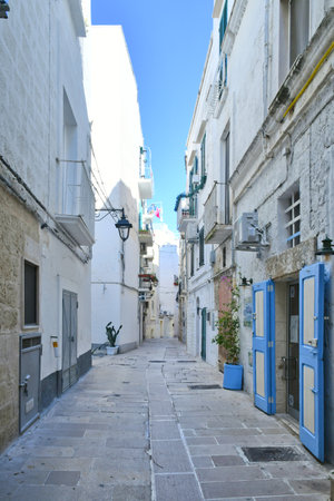 A narrow street among the old houses of Monopoli, a town in the province of Bari.の写真素材