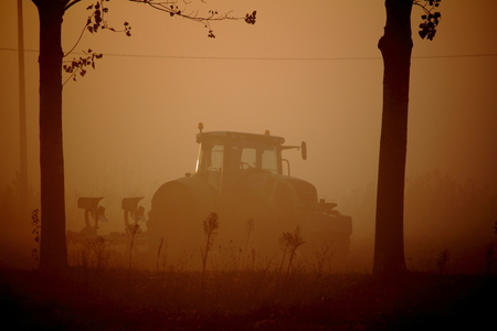 Foggy morning plowingの写真素材