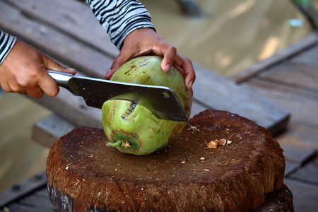 A man cutting a fresh coconutの写真素材