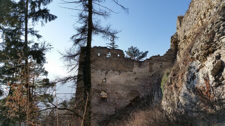 The ruins of a medieval castle Likava, rising above the village Likavkaの写真素材