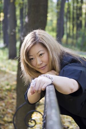 Asian woman on bridge fenceの写真素材