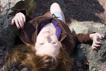 Beautiful young woman lying on the stoneの写真素材