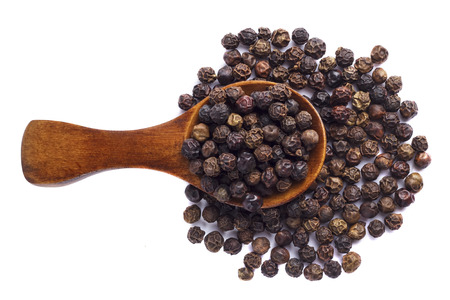Black pepper in wooden spoon on white background.