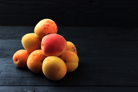 Apricots on black wooden backgroundの写真素材