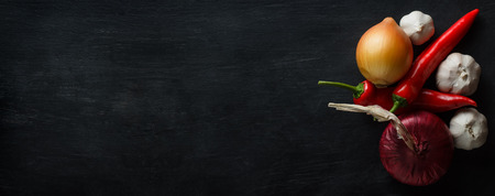 Vegetables red pepper, onions and garlic with a wide space for textの写真素材