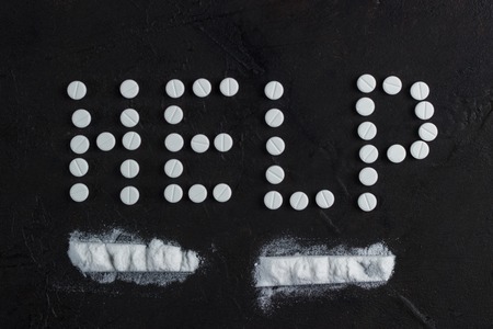 The inscription help laid out of the tablets and two tracks of powderの写真素材