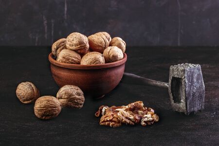 Walnuts in a bowl with a hammer