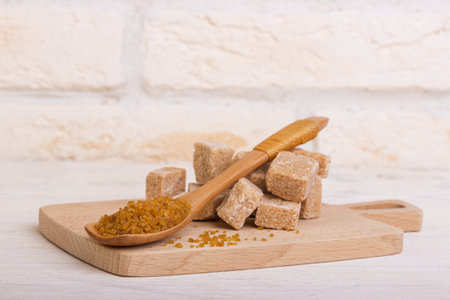 Pricked cane sugar and sugar in a spoon on a wooden boardの写真素材