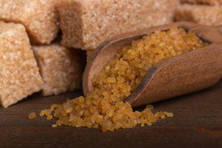 Brown cane sugar in a wooden spoon macroの写真素材