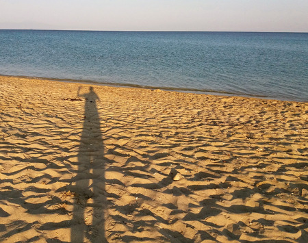Mans shadow on the mediteranean beach, Greeceの写真素材